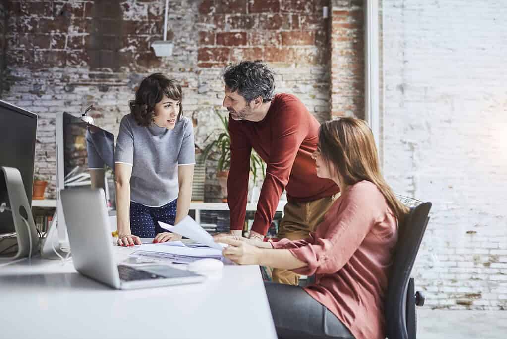A business owner and employees sitting at a table, creating a business plan.
